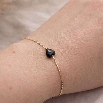 Bracelet minimaliste coeur noir en obsidienne acier inoxydable doré porté au poignet